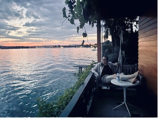 Füsse hochlagern, geniessen, nichtstun – auf der Terrasse am Wasser in der Abenddämmerung